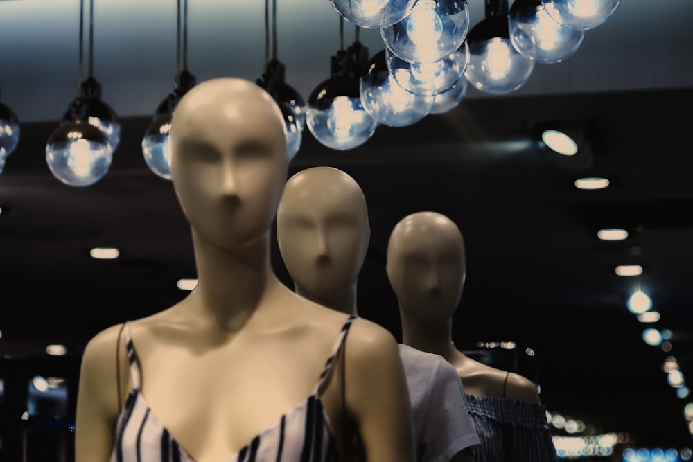 a group of mannequins with lights hanging from them