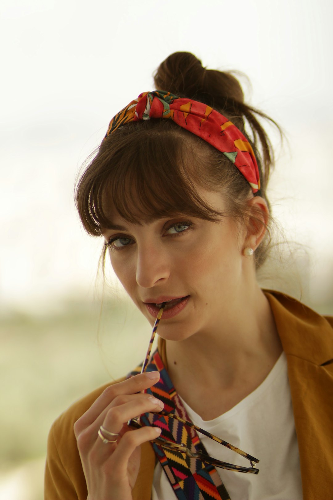 woman in red headband holding sunglasses