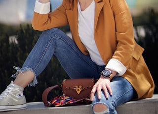 woman sitting on concrete bench near tree