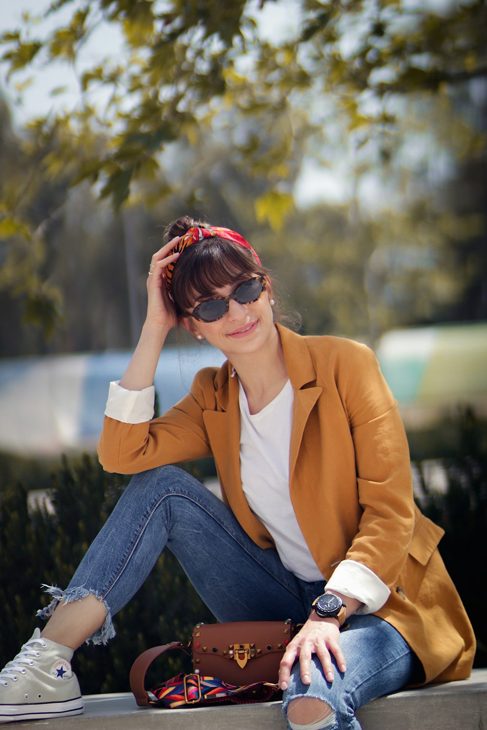 woman sitting on concrete bench near tree