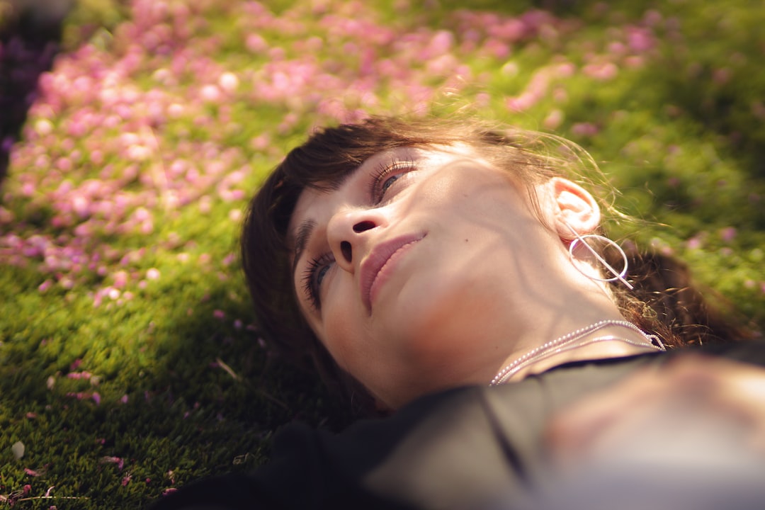 woman lying on green grass
