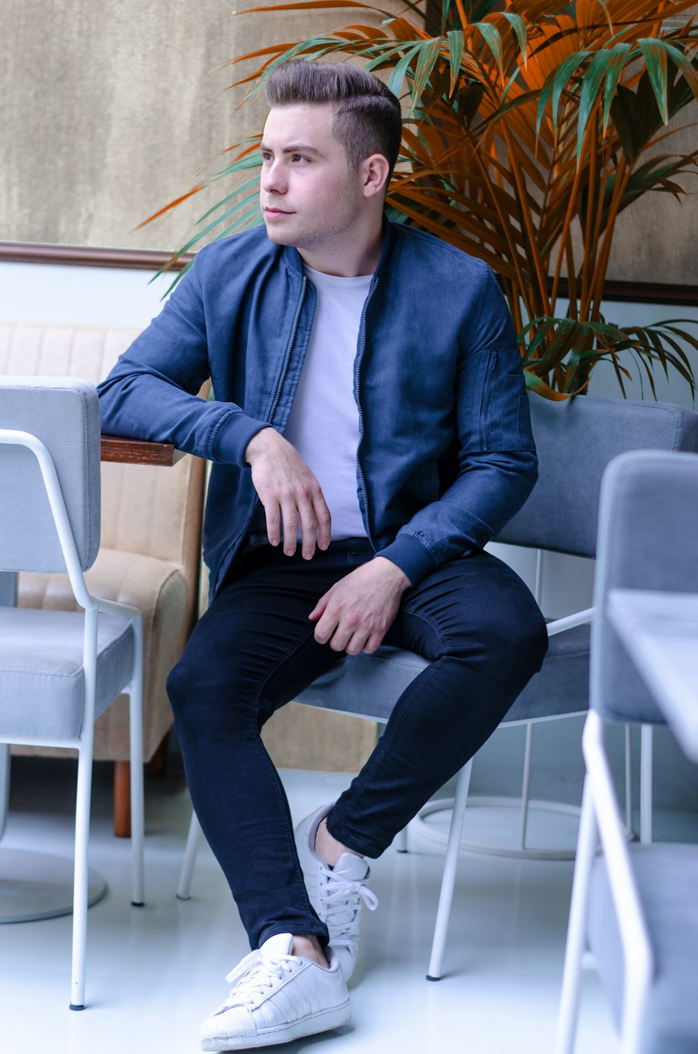 Foto hombre con chaqueta azul, blusa blanca, jeans azules y un par de  zapatos blancos sentado en una silla – Imagen Turco gratis en Unsplash