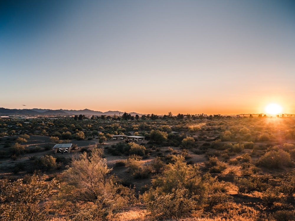 the sun is setting over a desert landscape