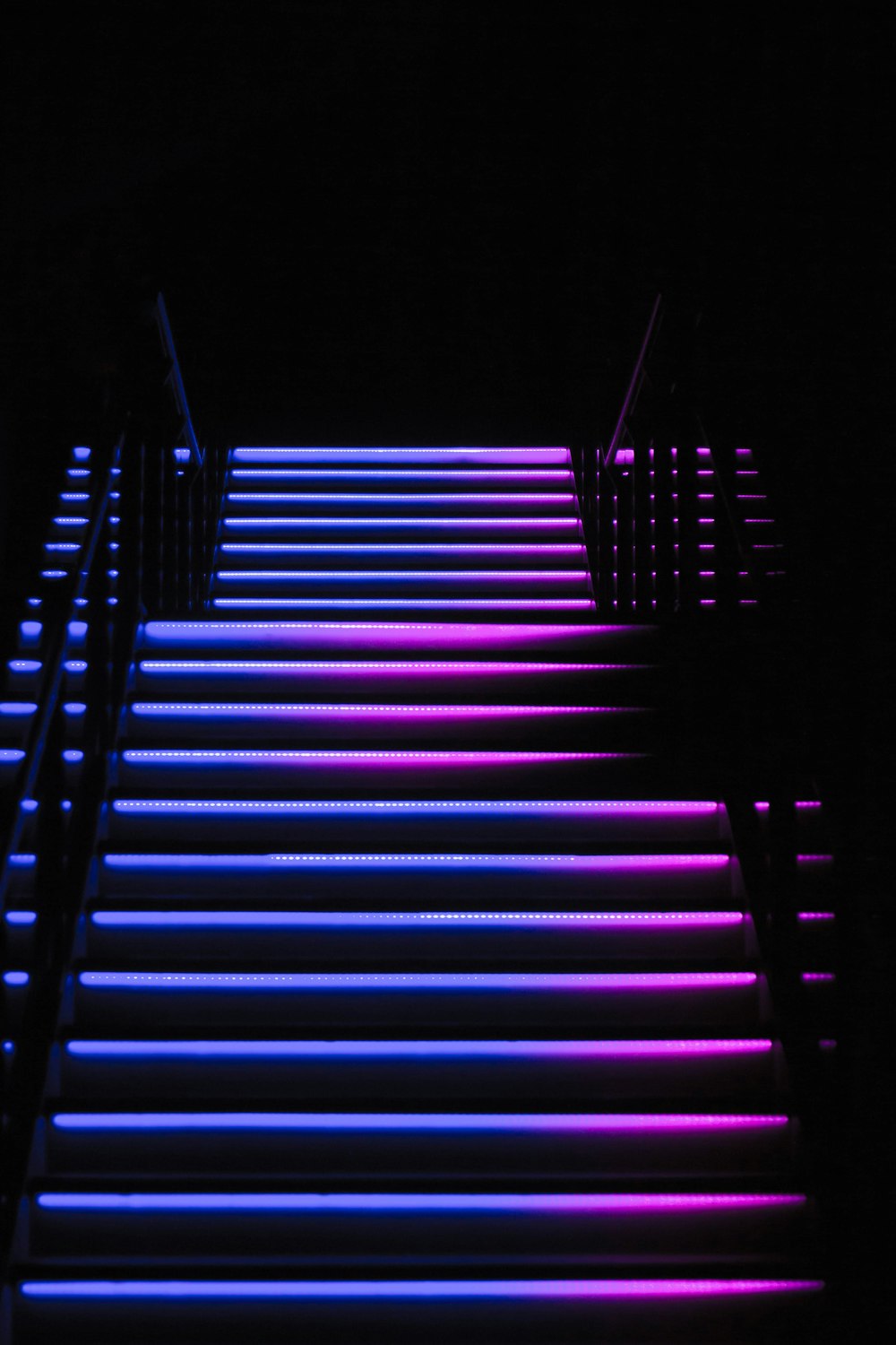 a set of stairs lit up with neon lights