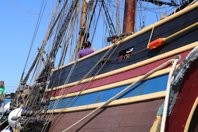A vibrant photo of the large 'Piratas do Porto' schooner sailing near Bombinhas with passengers enjoying the deck.