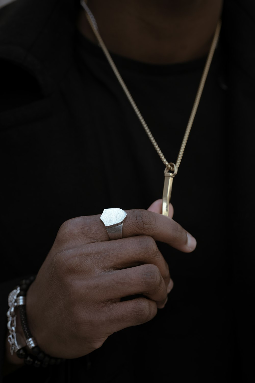 person holding gold-colored pendant