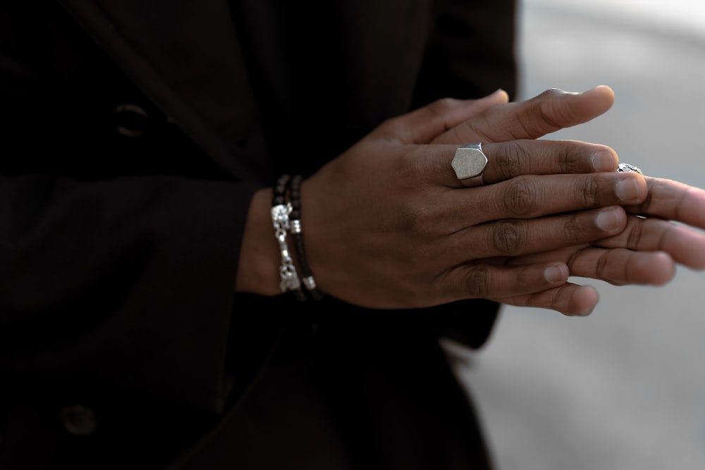 person wearing silver-colored ring