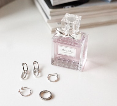 clear glass perfume bottle on white wooden table