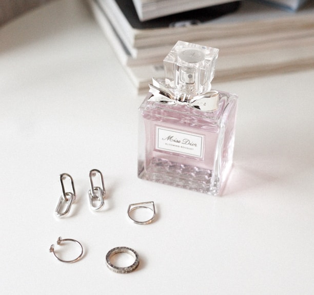 clear glass perfume bottle on white wooden table