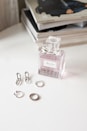 clear glass perfume bottle on white wooden table