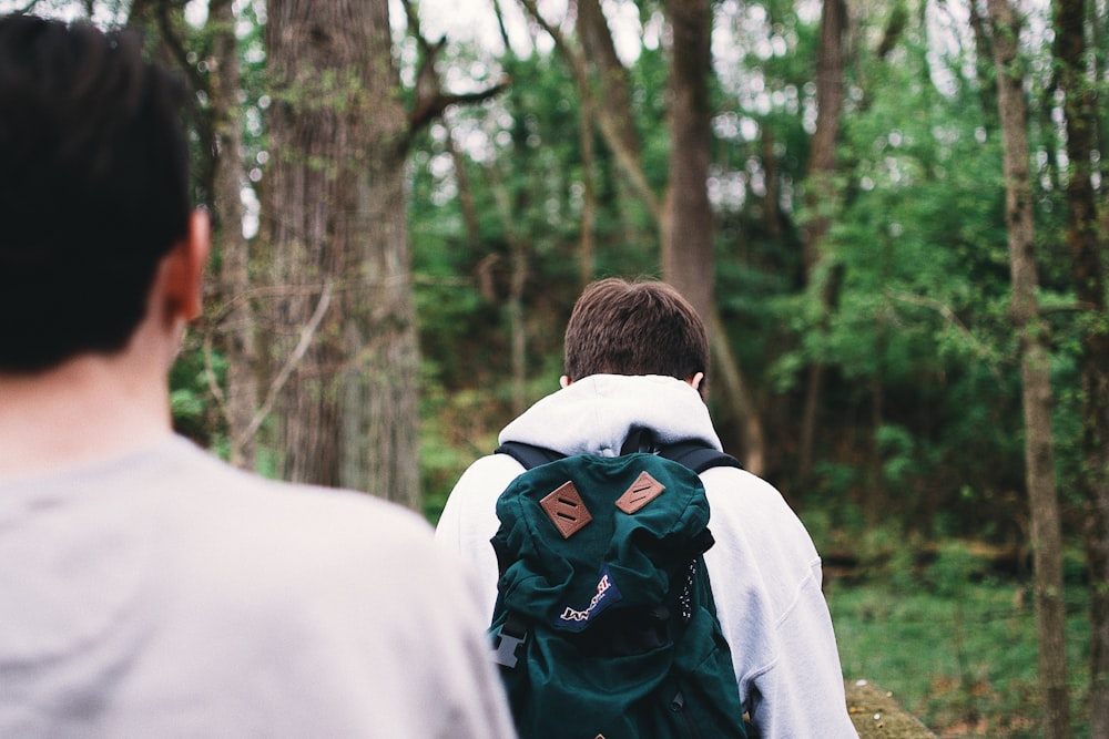 two men walking near trees