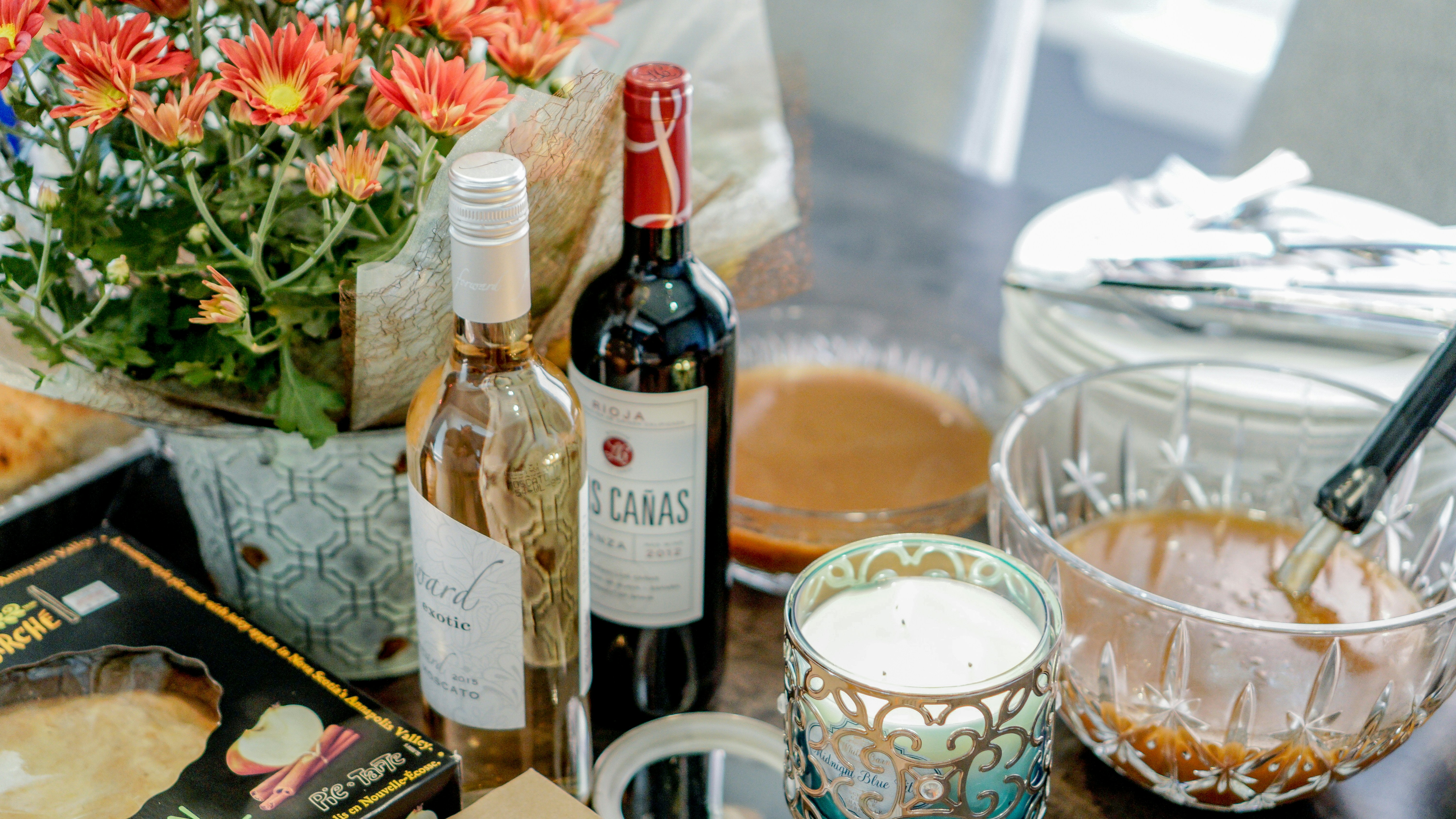 una mesa cubierta con botellas de vino y un tazón de comida