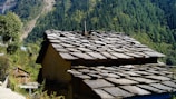 A slate roof being installed on a rustic countryside home.
