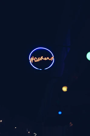 Close-up of a glowing acrylic sign with blue neon lighting in a modern office setting.