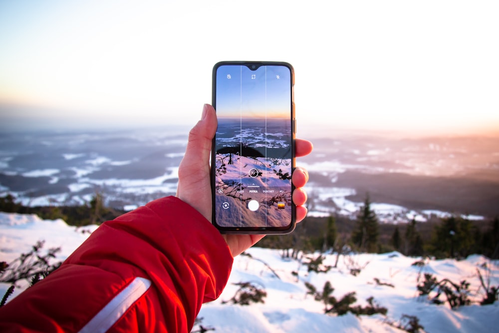 person using smartphone camera viewing glacier field