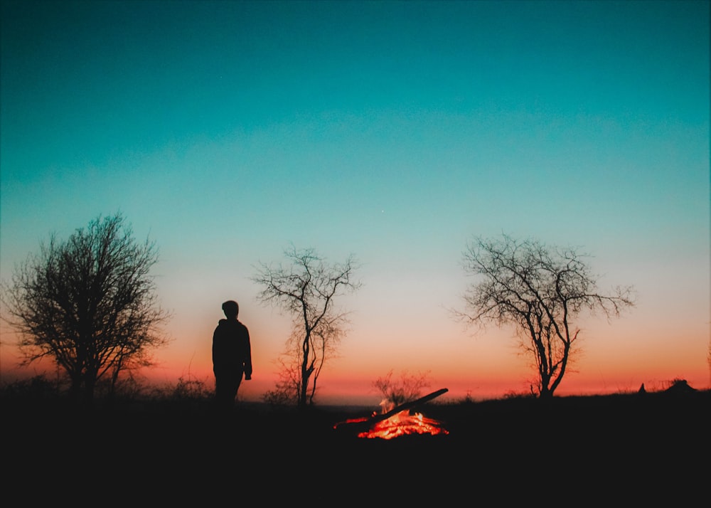man standing silhouette near bonfire