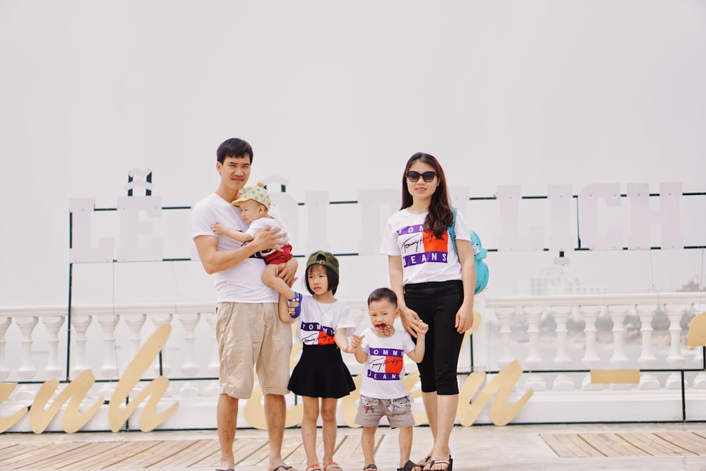 family standing on wooden floor during daytime