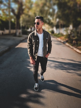 Casual streetwear look with a man wearing a white tee and khaki pants in a sunlit alley.