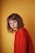 woman wearing red long-sleeved shirt beside wall