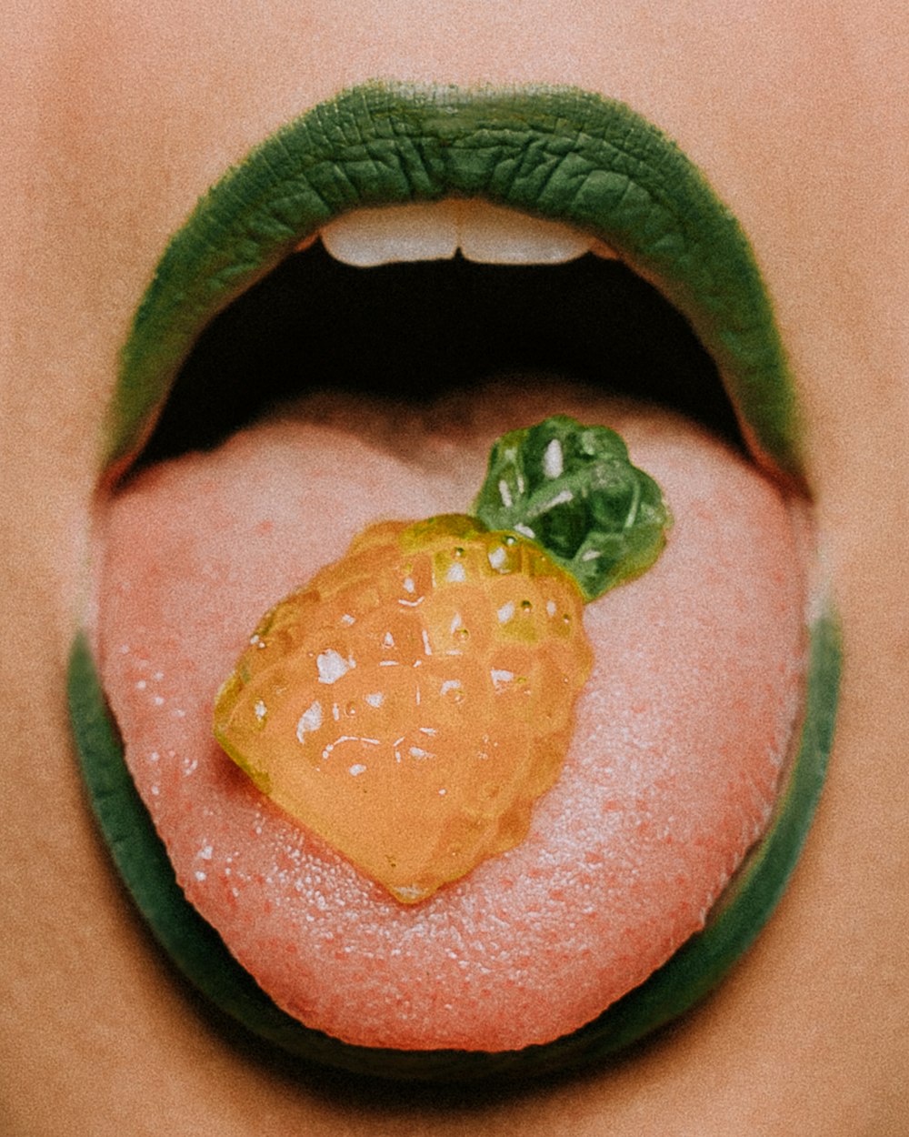 파인애플 사탕으로 혀를 보여주는 사람