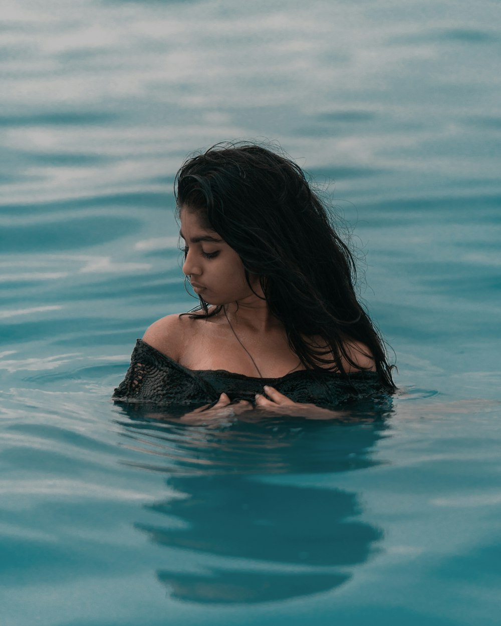 woman wearing black boat-neck top in body of water close-up photography