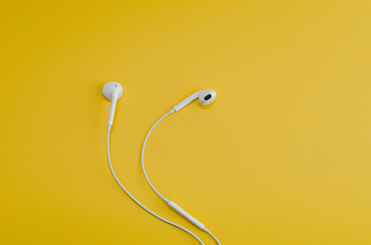 White wired earbuds on a yellow background