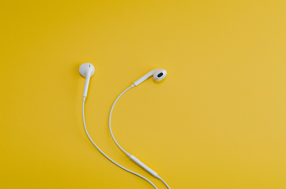 노란색 표면의 Apple EarPods