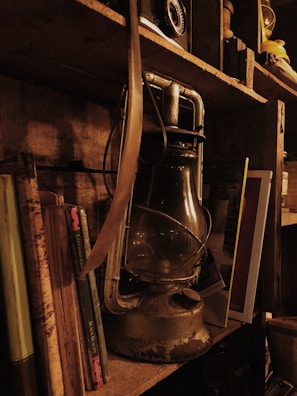 An antique lantern casting a warm glow on a dusty, forgotten diary.