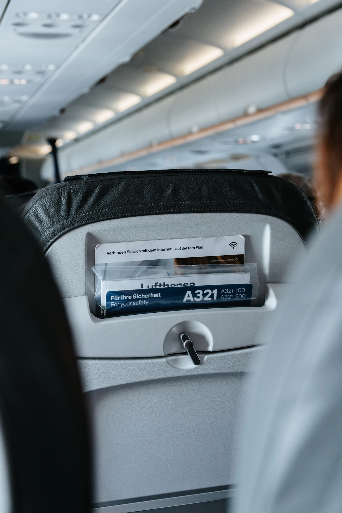 Passenger seated by the window inside an airplane cabin