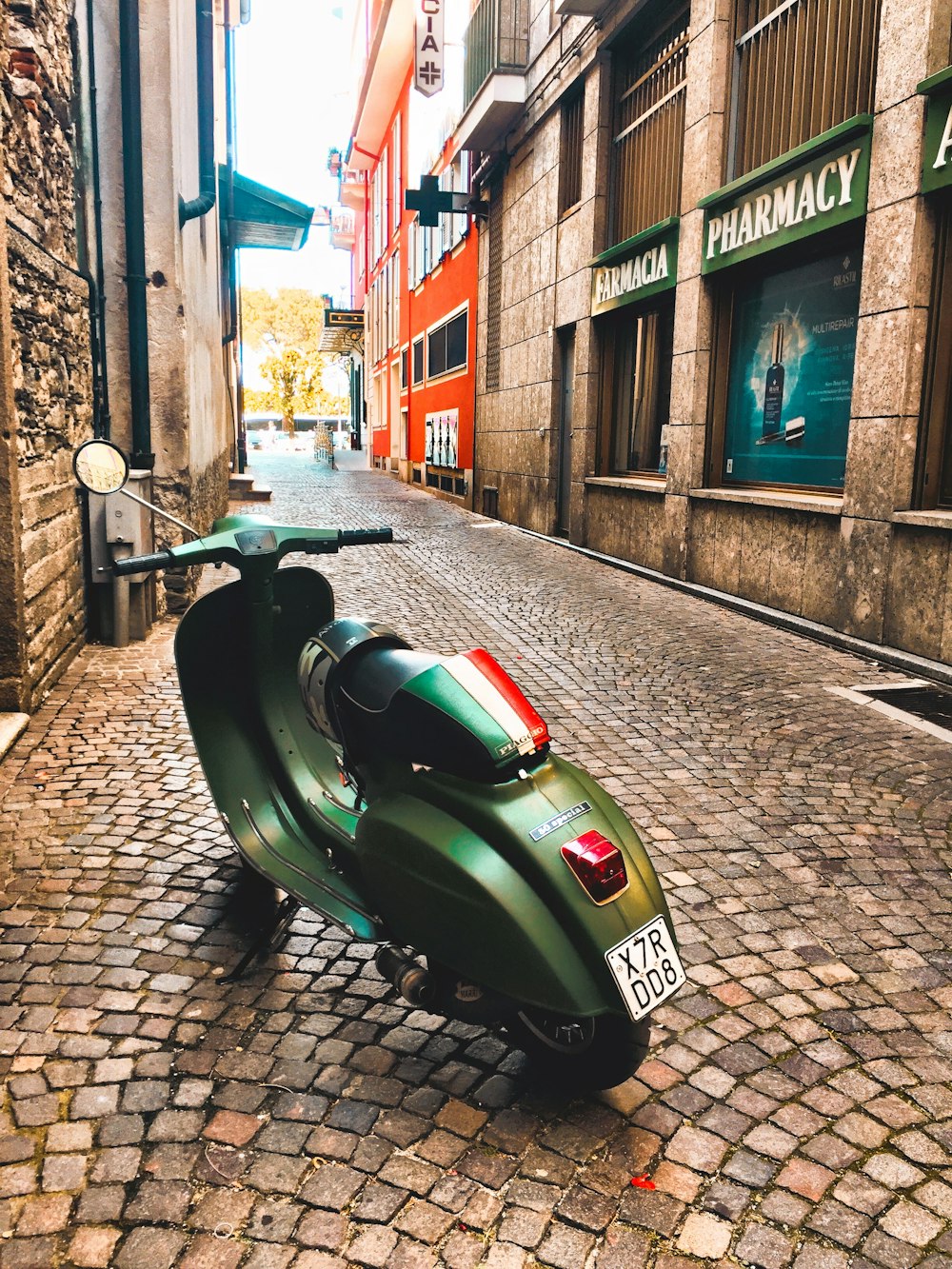 green motor scooter parked beside building