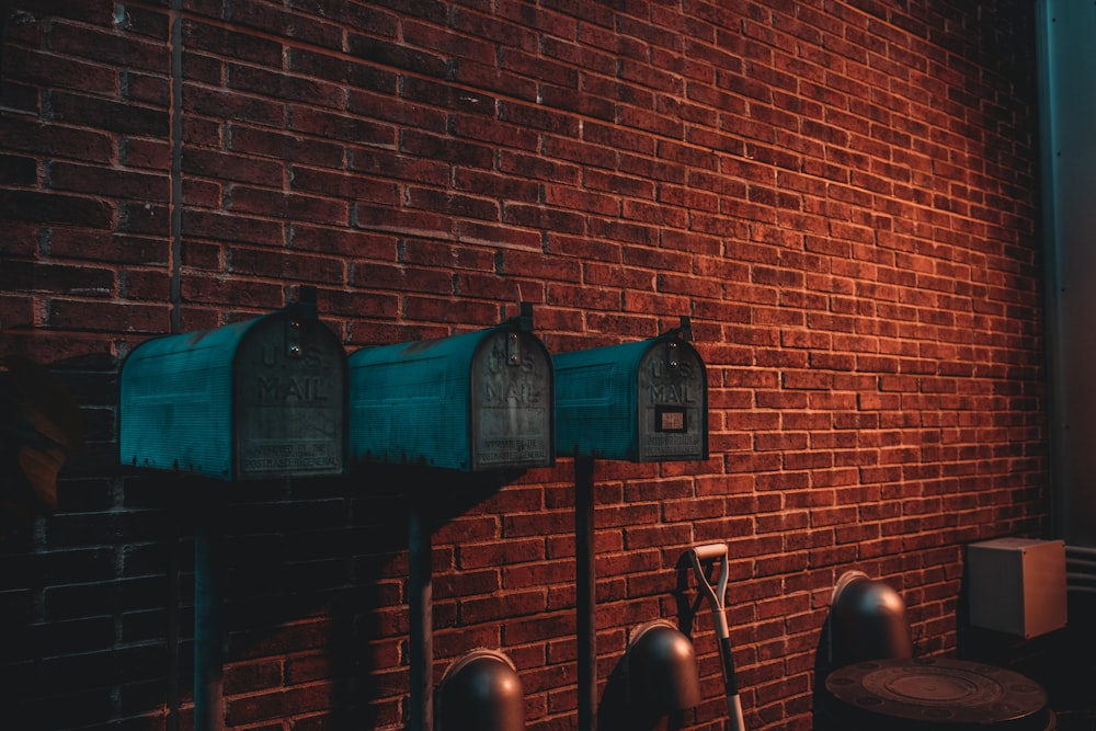 three green mail boxes near wall