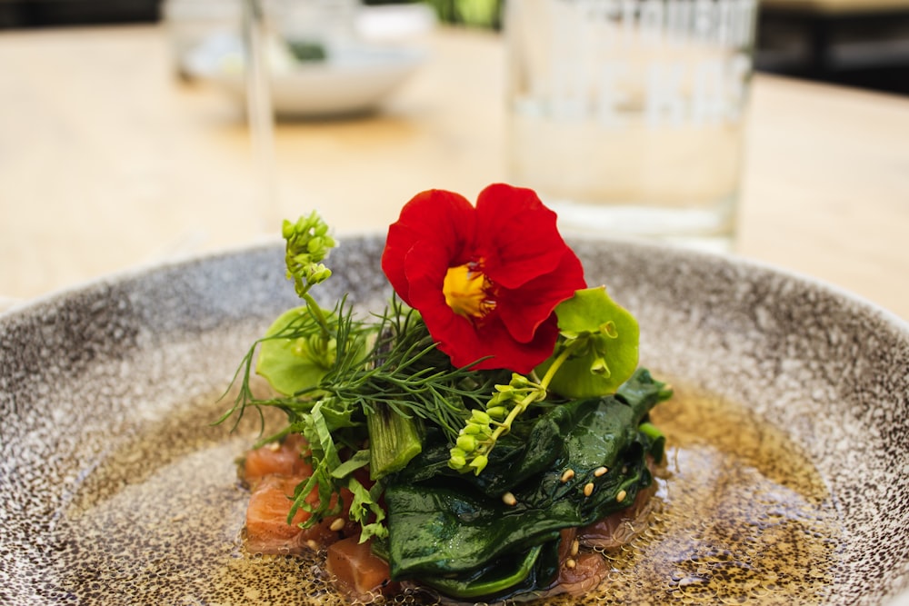 접시에 야채와 빨간 꽃잎이 달린 꽃의 클로즈업 사진