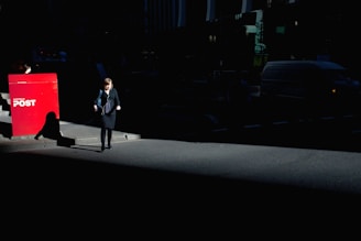 A delivery person placing flyers into residential letterboxes on a sunny Gold Coast street.