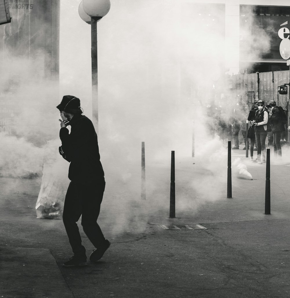 grayscale photo of man near smoke