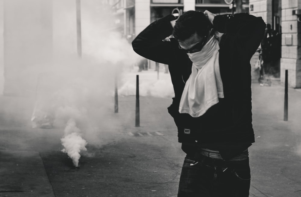 man standing and covering his face using shirt