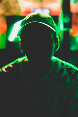 A bold cap with a glowing neon green embroidered samurai emblem against a charcoal background.