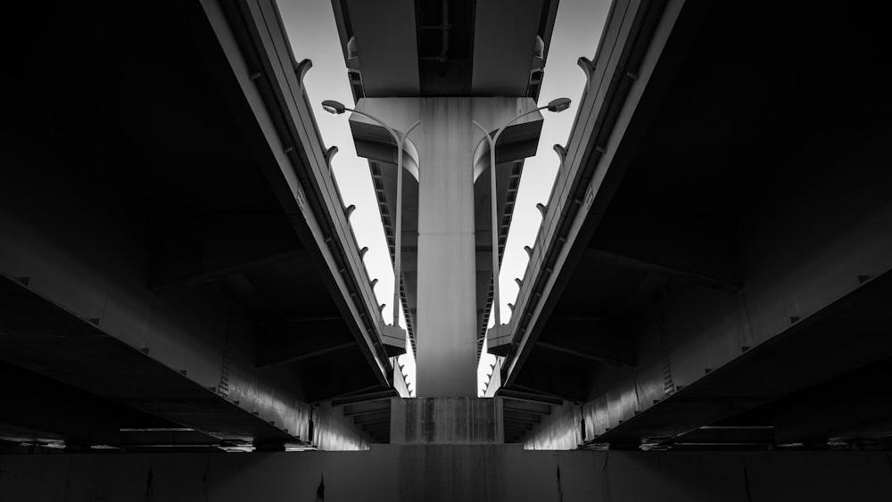 grayscale photo of under the bridge