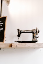 black and brown Singer sewing machine near wall