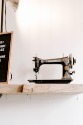 black and brown Singer sewing machine near wall