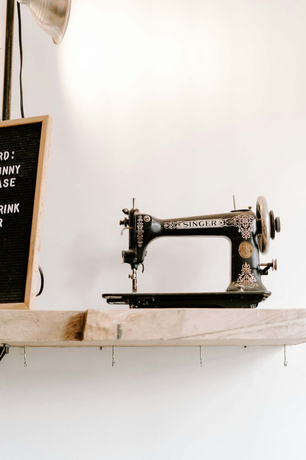 black and brown Singer sewing machine near wall