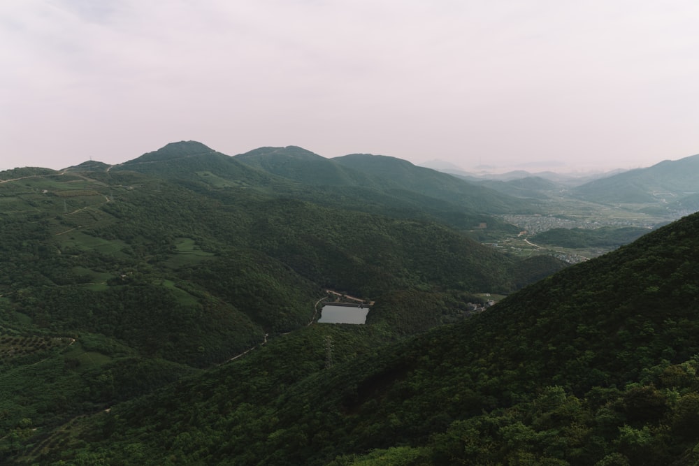 mountain covered with green-leafed trees under white clouds