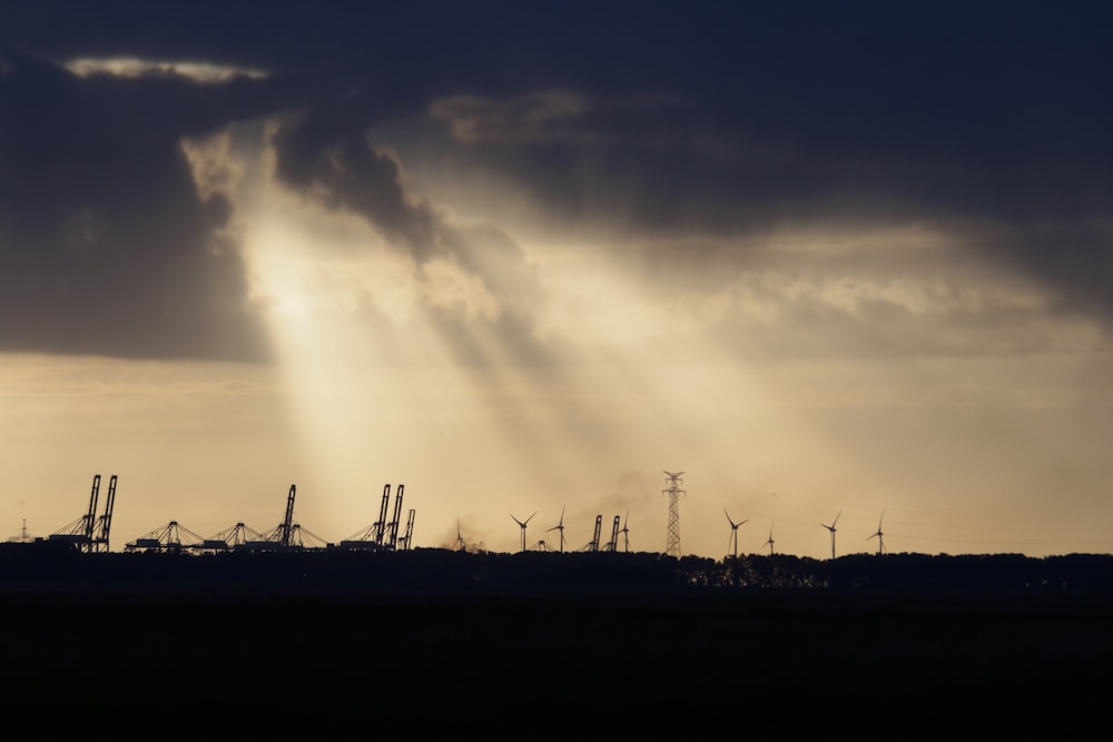 silhouette of windmills under cloudy sky