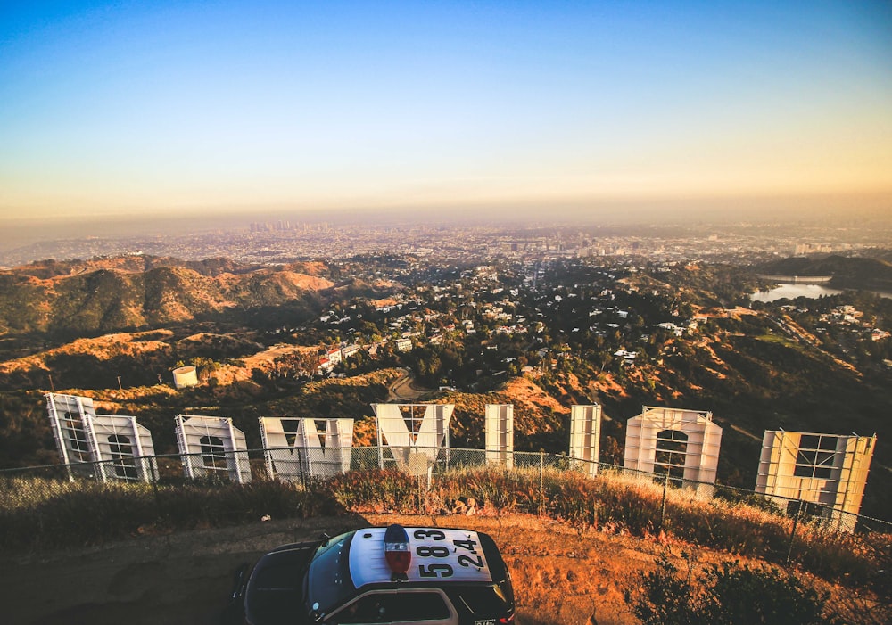 Coche de policía aparcado cerca de la señalización de Hollywood durante el día