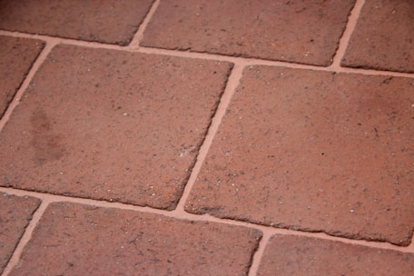 Close-up of a skilled craftsman laying ceramic tiles in a modern kitchen.