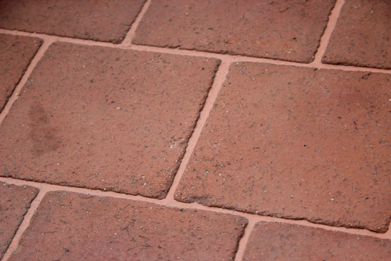 Close-up of a craftsman carefully laying patterned ceramic tiles on a floor.
