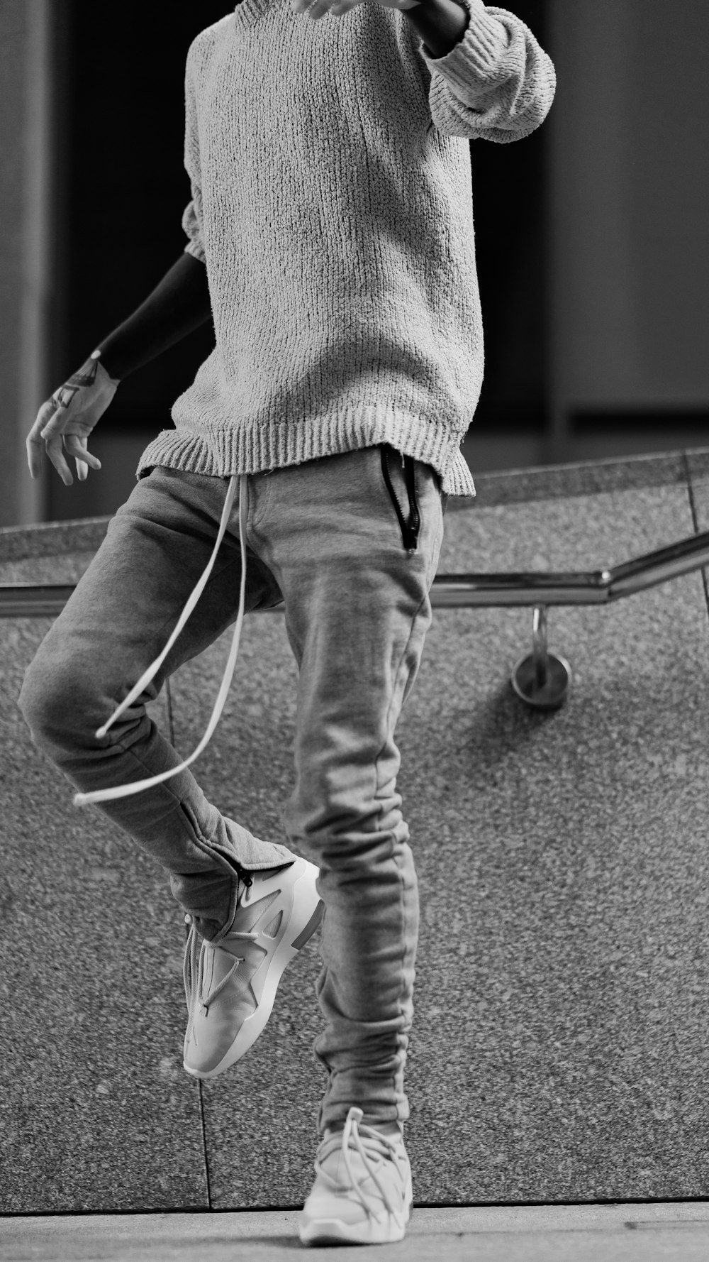 grayscale photography of person wearing sweater and pants