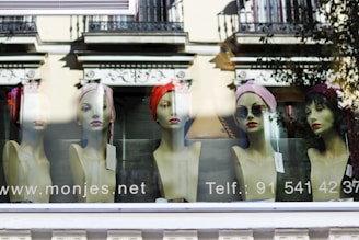 Fashionable hats displayed on mannequin heads in a bright store corner.