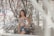 A stylish woman posing in a floral garden, radiating beauty and confidence.