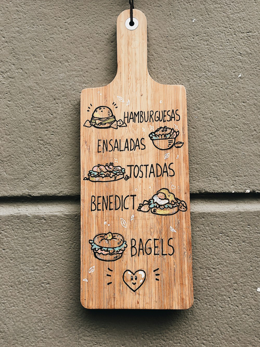 brown wooden paddle with menu hanging beside wall
