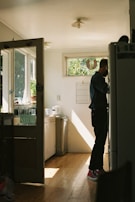 Wide shot of a spacious kitchen with newly installed hardwood floors reflecting warm tones.